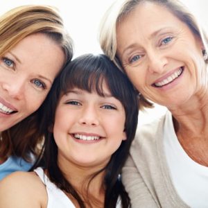 womancare Closeup portrait of grandmother with daughter and granddaughter sitting and smiling - Indoors